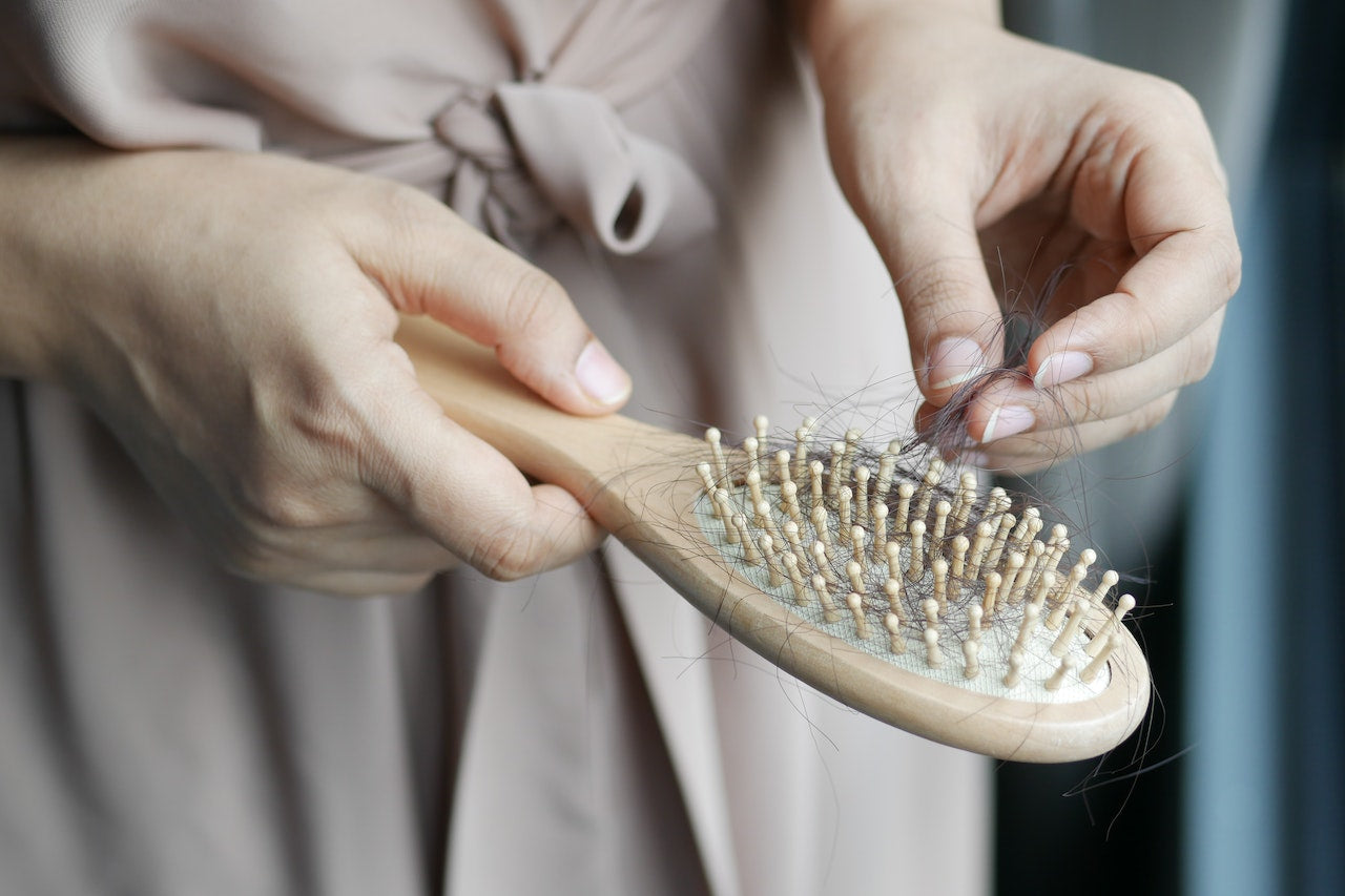 Femme perdant ses cheveux après l'accouchement - chute post-partum solutions naturelles